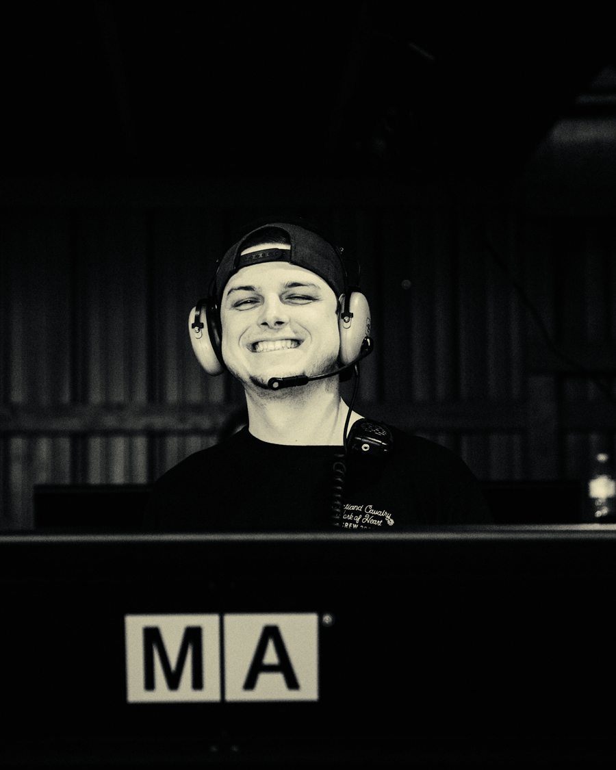 Chris Haynes grinning in a headset behind a grandMA3 console
